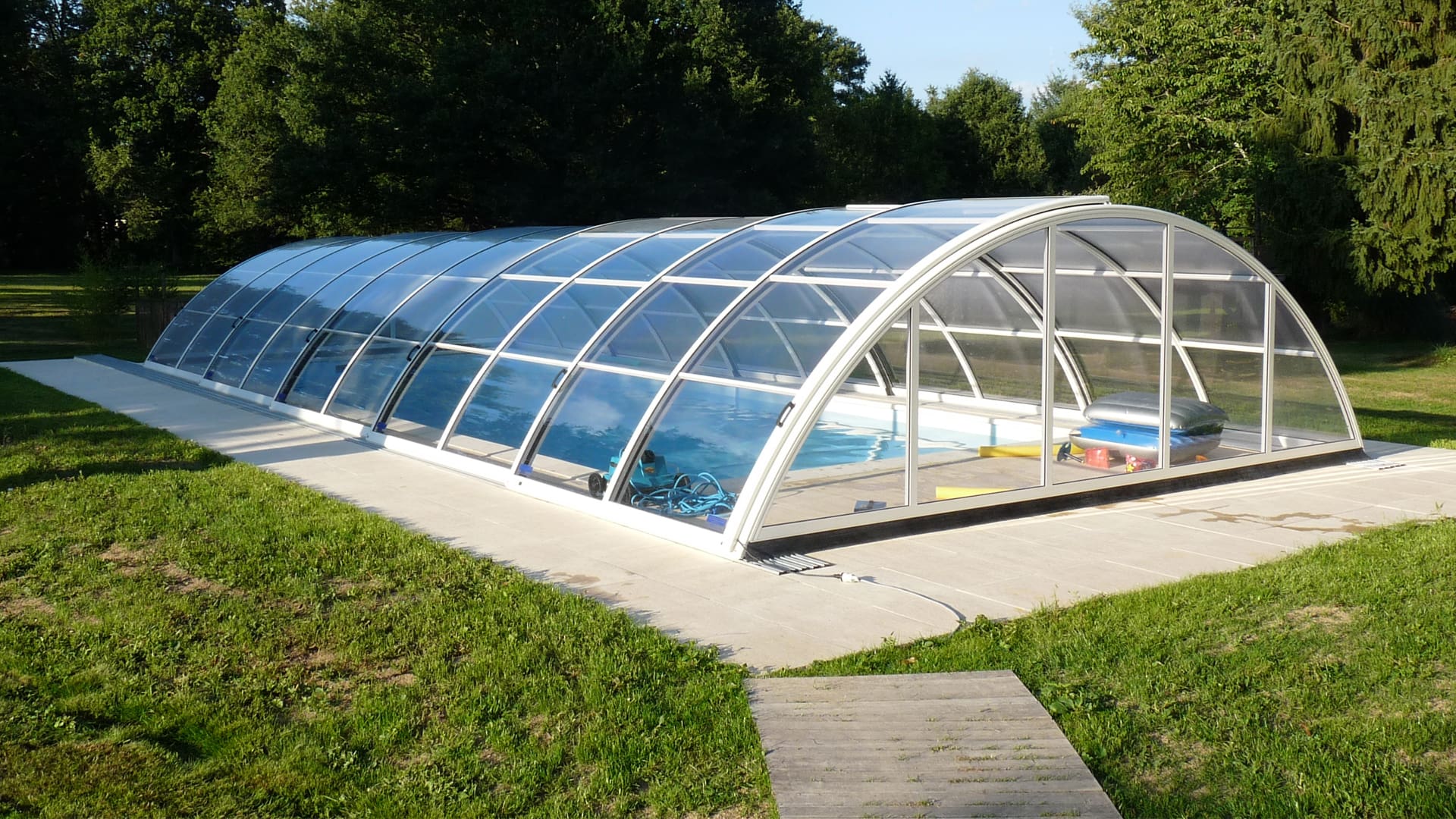 Piscine dans un beau jardin sous un ciel ensoleillée avec un abri