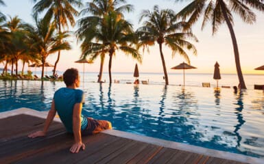 Un homme assis au bord de piscine