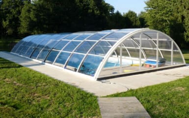 Piscine dans un beau jardin sous un ciel ensoleillée avec un abri