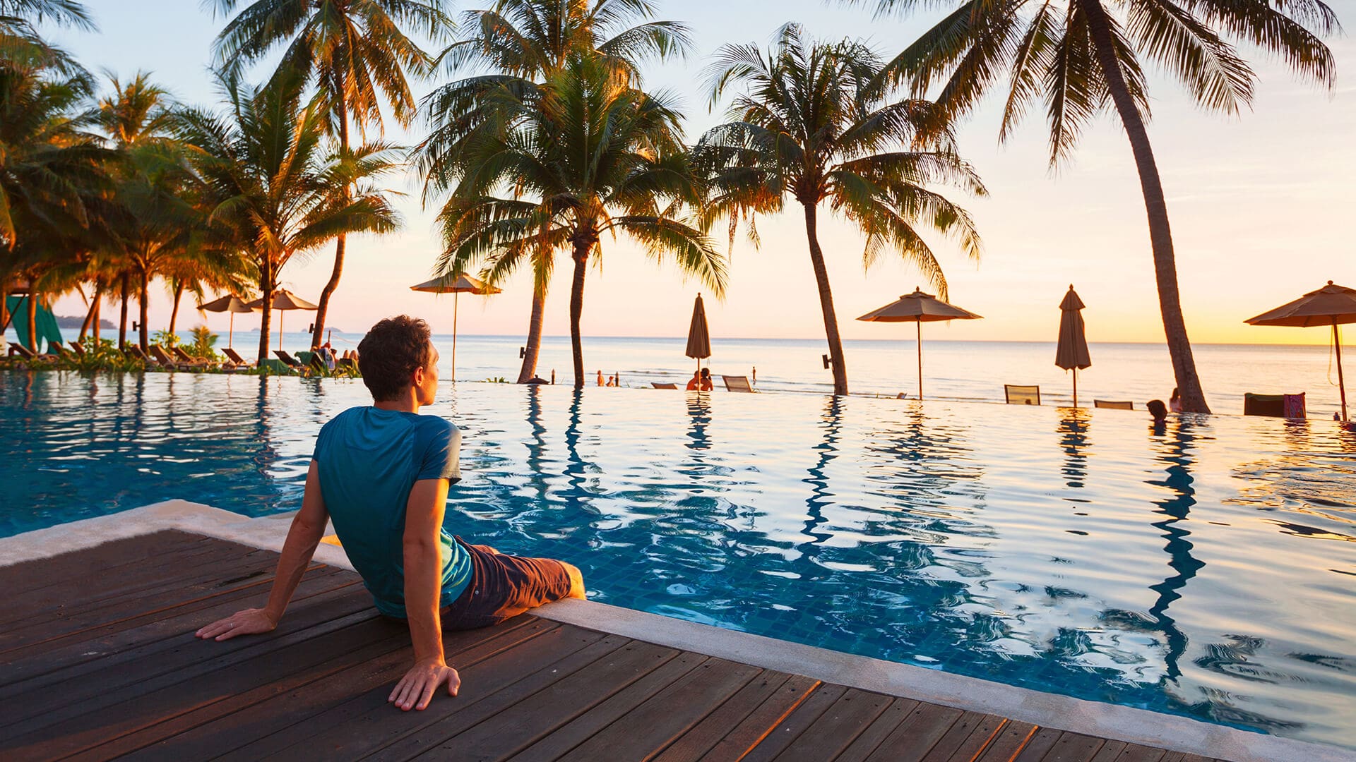 Un homme assis au bord de piscine